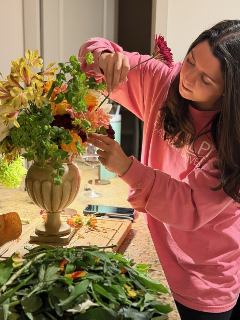 Close up of Austin wedding planner refining floral details for a luxury tablescape design.