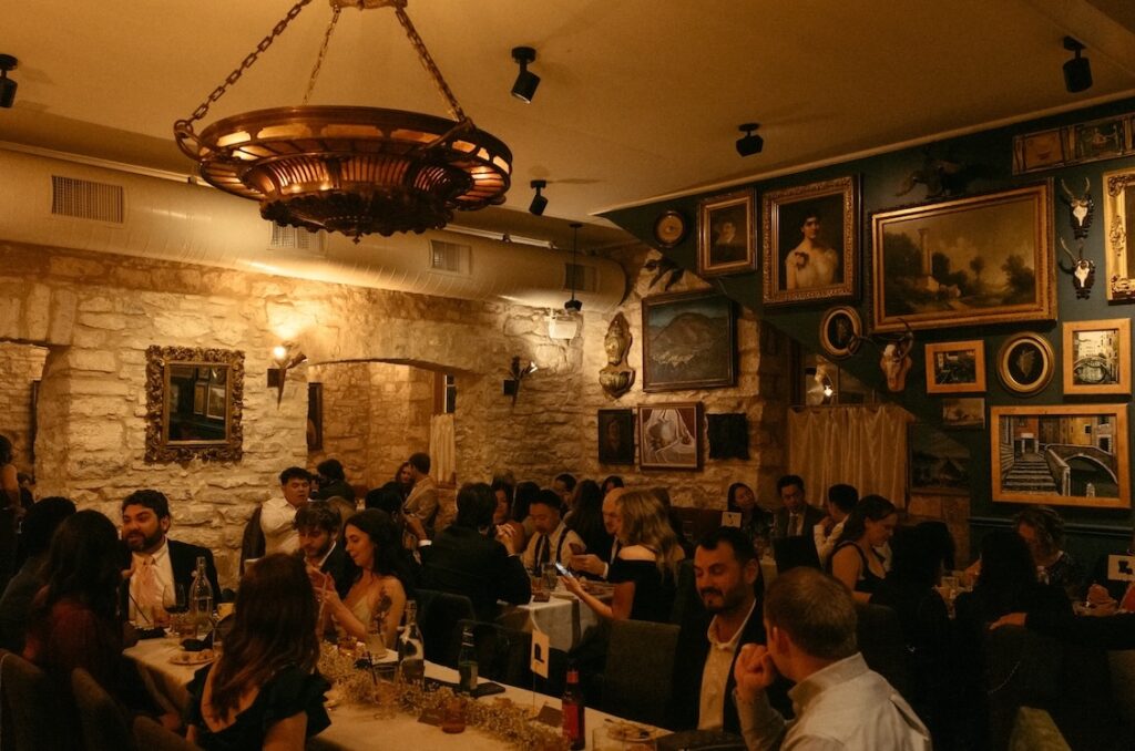 A wide shot of a wedding reception at Alla Campagna in Fredericksburg, featuring original limestone and wood paneling.